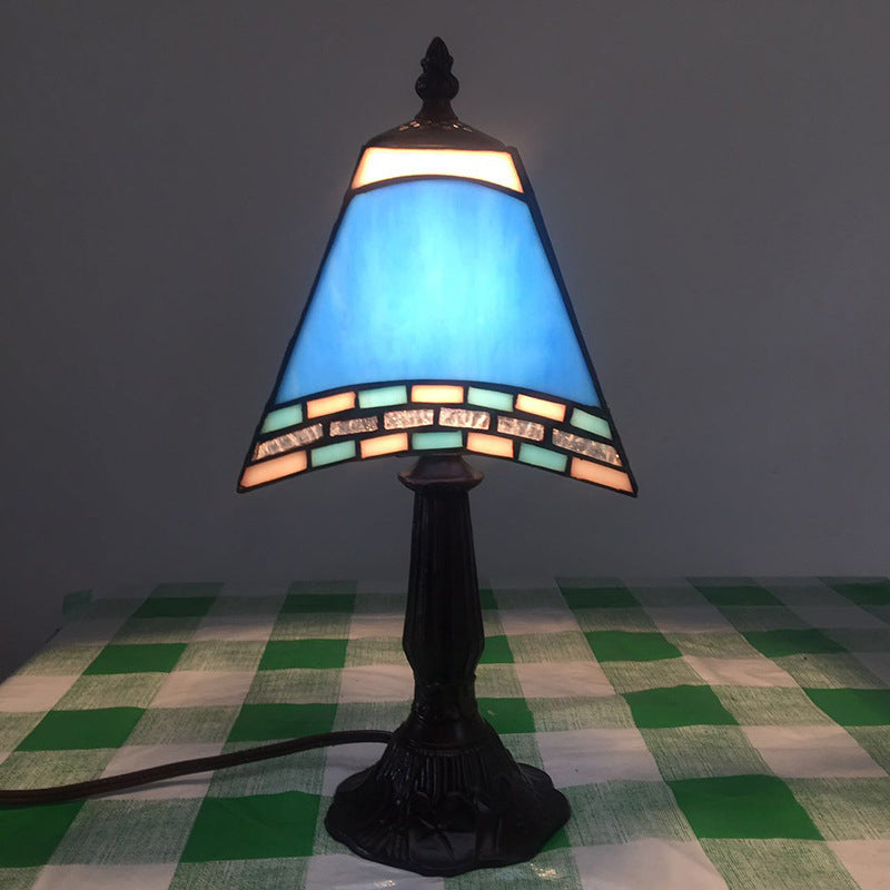Morska lampka nocna ze szklanym kloszem przy łóżku