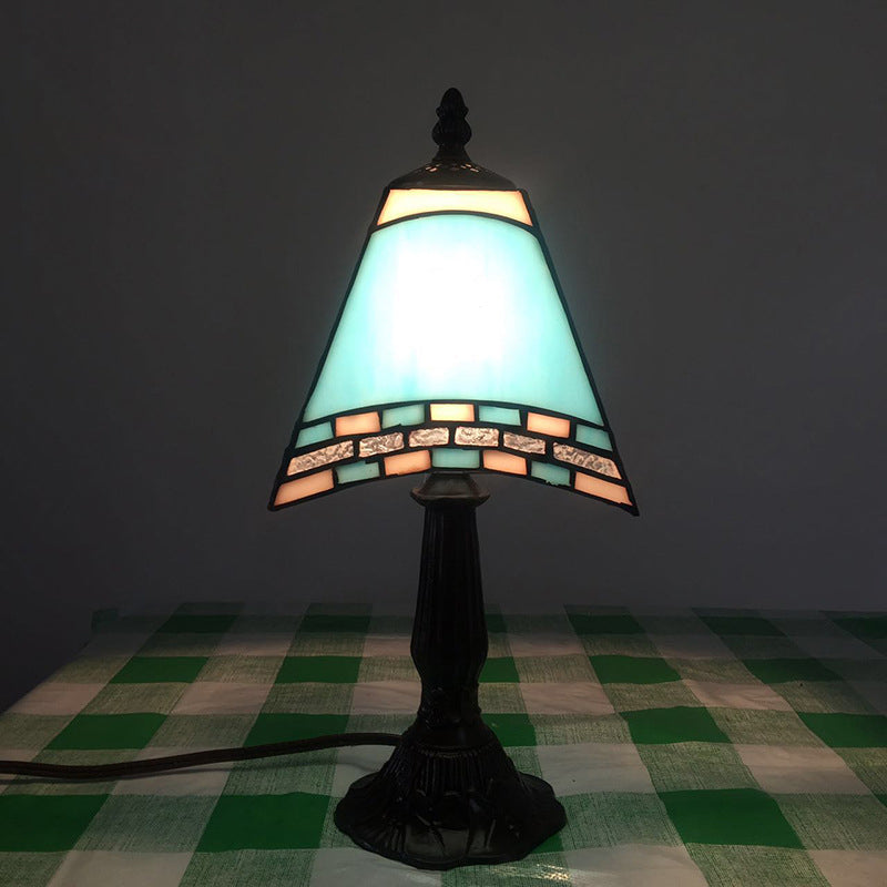 Morska lampka nocna ze szklanym kloszem przy łóżku